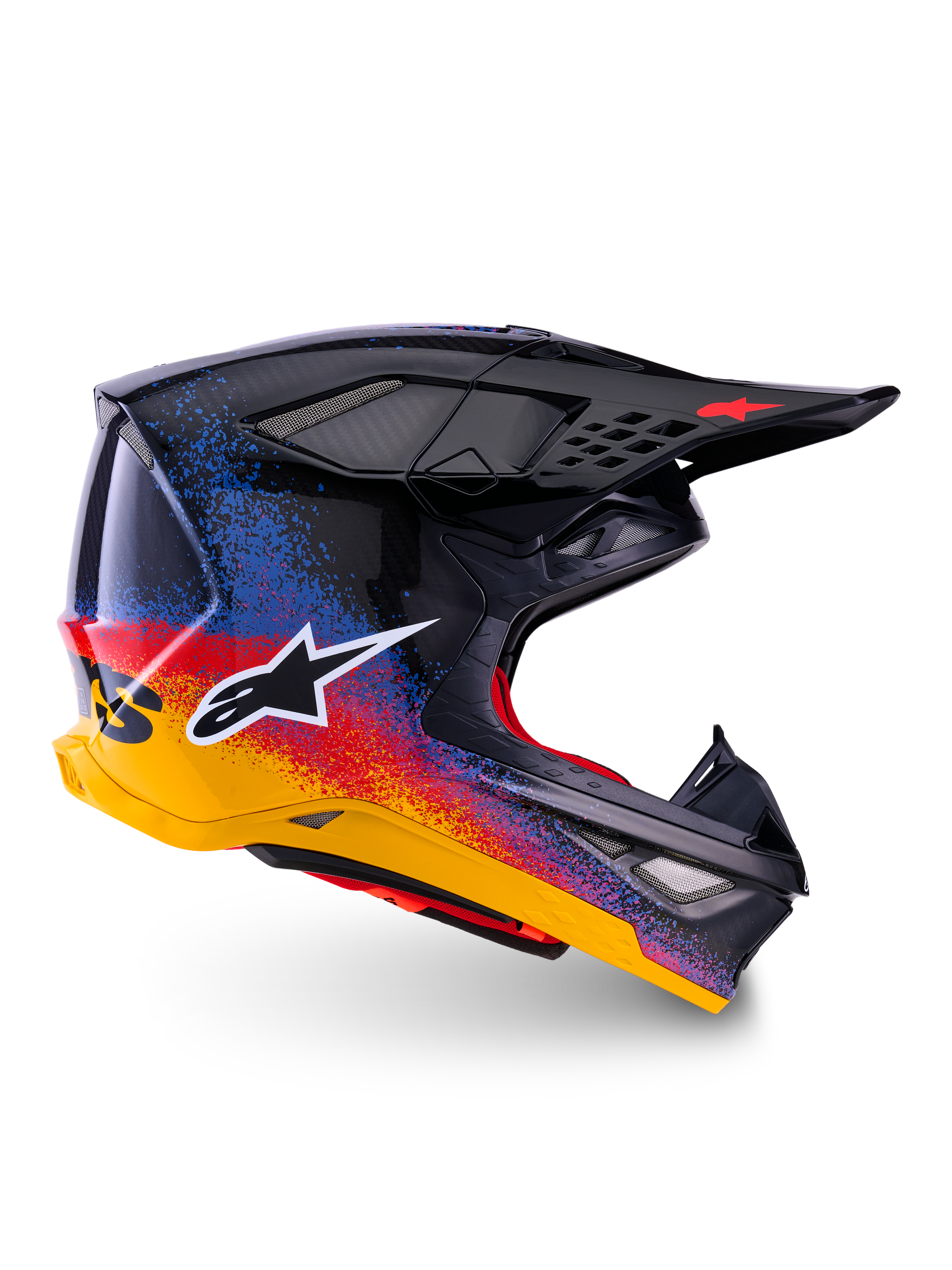 Alpinestars Limited Edition Supertech M10 Black Hole, kask motocrossowy, czarna skorupa z czerwonym, niebieskim i żółtym gradientowym wzorem typu splatter, białe logo gwiazdy z boku, aerodynamiczny profil z otworami wentylacyjnymi osłoniętymi siatką, czerwona wyściółka i długi czarny daszek.