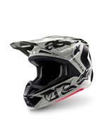 Kask Alpinestars Limited Edition S-M7 Wolf Dust, kask motocrossowy, Dune Black Glossy, jasnoszara skorupa z czarnym gotyckim napisem „ASTARS” i logo gwiazdy, czerwony akcent na dolnej krawędzi, wyposażony w wysokowydajny daszek i liczne wloty powietrza, widok z przodu pod kątem trzech czwartych