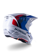 Alpinestars Honda S-M5 Helmet ECE, kask motocrossowy, biało-niebiesko-czerwony z połyskiem, z wyraźnym brandingiem Honda i logo Alpinestars, aerodynamiczna skorupa ze zintegrowanymi otworami wentylacyjnymi i regulowanym daszkiem, sprzęt ochronny do wyścigów off-road