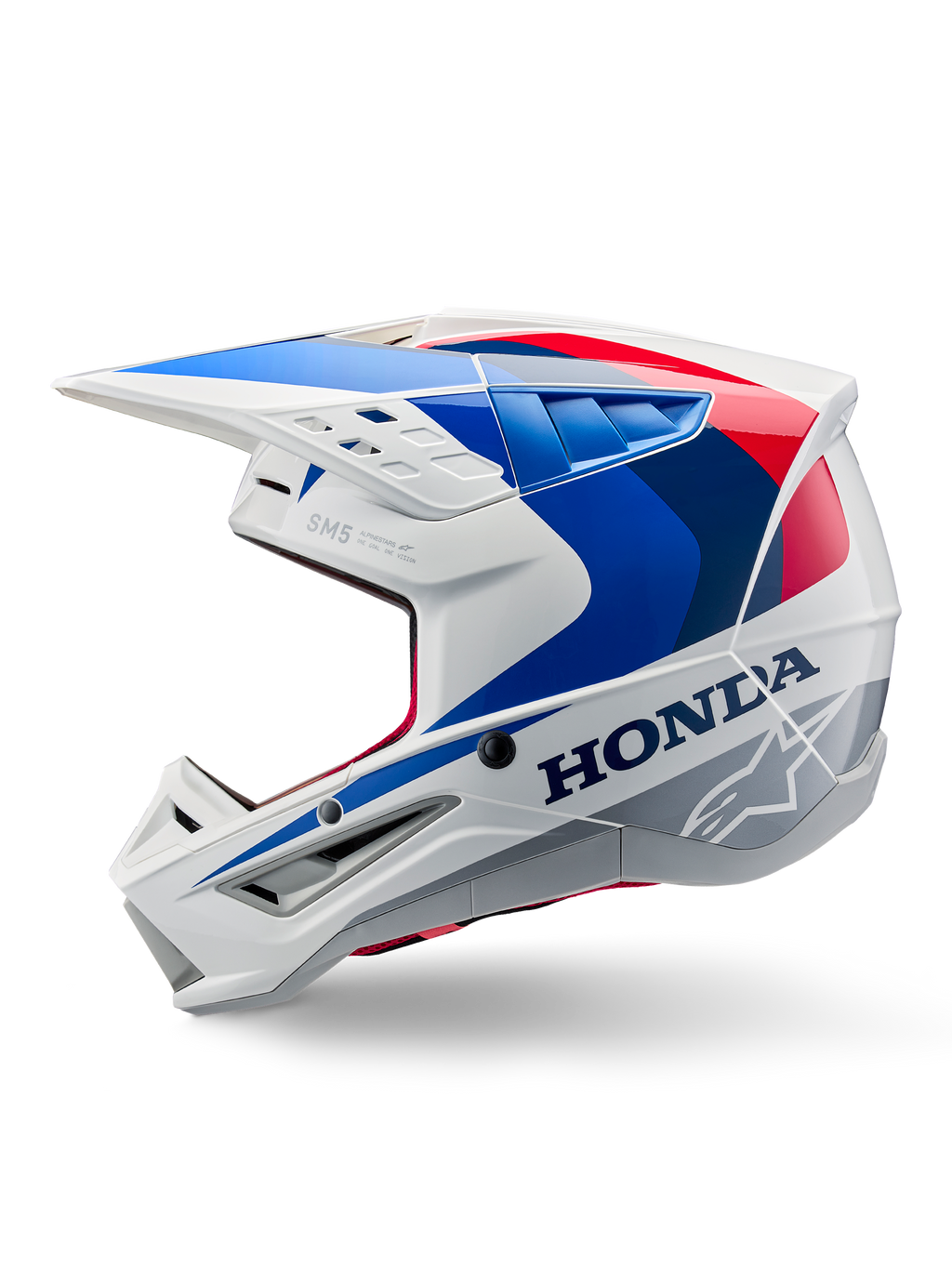 Kask Alpinestars Honda S-M5 ECE, biało-niebiesko-czerwony połysk, widok z boku, z wyraźnym brandingiem Honda i logo gwiazdy Alpinestars, aerodynamiczny design motocrossowy z licznymi otworami wentylacyjnymi i wyraźnym daszkiem, błyszczące wykończenie