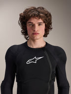 Model w kurtce ochronnej Alpinestars A-Impact Plasma - długi rękaw, czarna z białym logo Astars, z przesuniętym przednim zamkiem błyskawicznym i zintegrowanymi ochraniaczami, profesjonalna odzież ochronna MTB