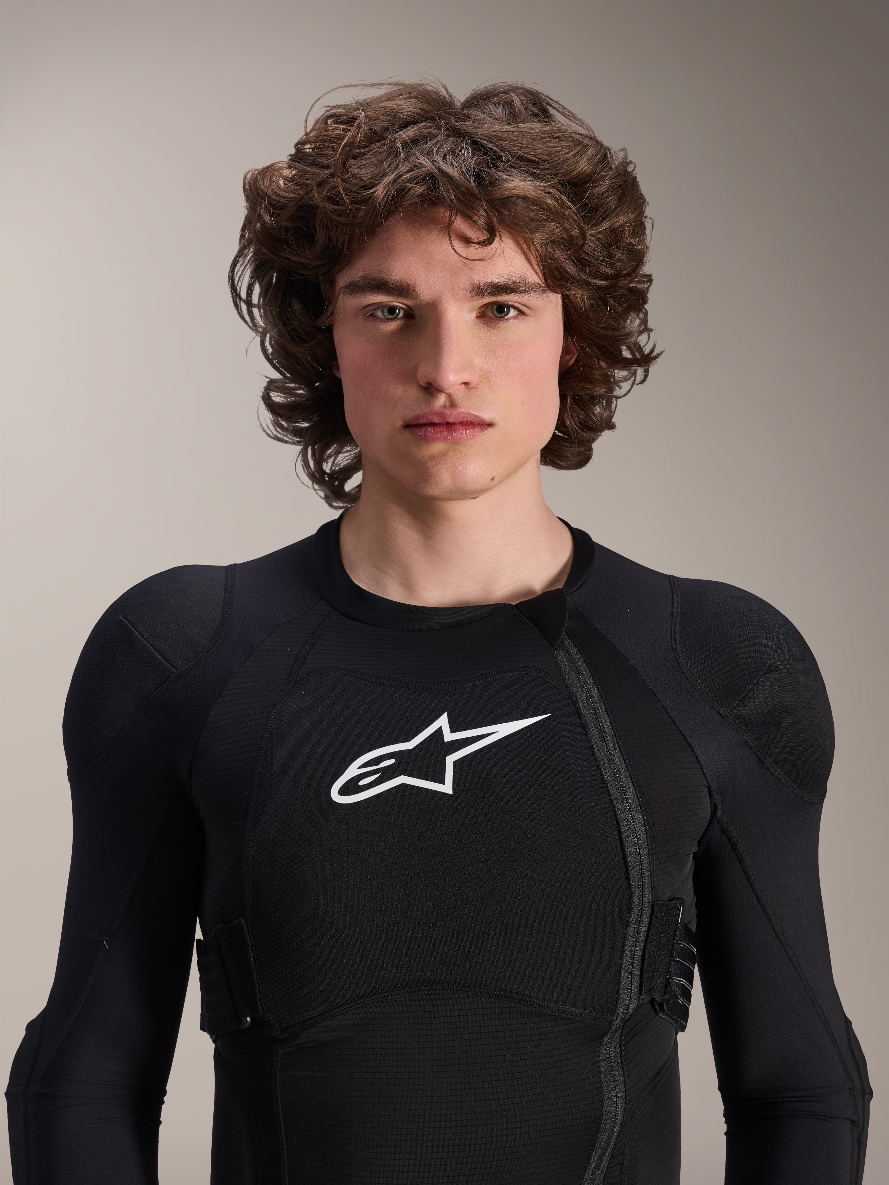 Model w kurtce ochronnej Alpinestars A-Impact Plasma - długi rękaw, czarna z białym logo Astars, z przesuniętym przednim zamkiem błyskawicznym i zintegrowanymi ochraniaczami, profesjonalna odzież ochronna MTB