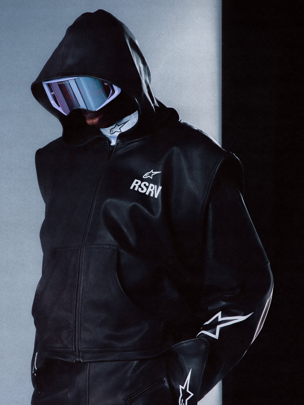 Alpinestars RSRV Axis Leather Hoodie, czarna skórzana bluza z kapturem, logo RSRV i gwiazdy, futurystyczny styl streetwear, premium skórzana konstrukcja