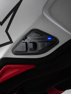 Alpinestars A-Connect Communication System, jednostka sterująca interkomem motocyklowym z układem 4 przycisków i aktywną niebieską diodą LED stanu, zamontowana na skorupie kasku