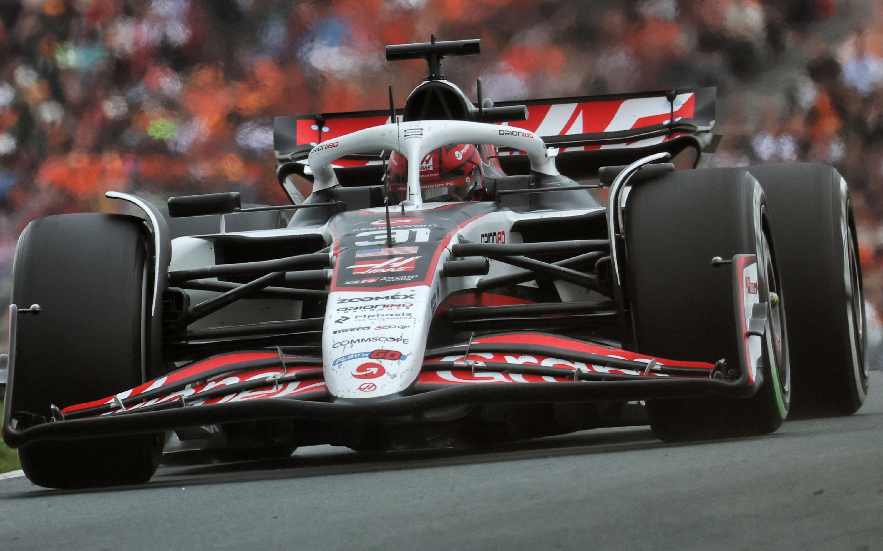 Esteban Ocon in his Haas Formula 1 car during a race, with blurred background