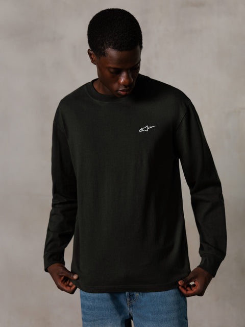 Alpinestars Essentials Ageless LS Tee, koszulka z długim rękawem, Off Black, małe białe logo na piersi, model w niebieskich dżinsach, casualowy styl streetwear