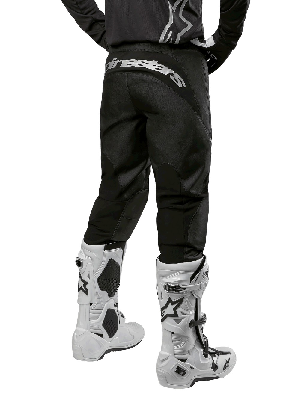 Zestaw Alpinestars 2024 Fluid Graphite, widok z tyłu czarno-szarych spodni motocrossowych z białym brandingiem Alpinestars na siedzeniu, biało-czarne buty motocrossowe, specjalistyczna odzież do wyścigów terenowych