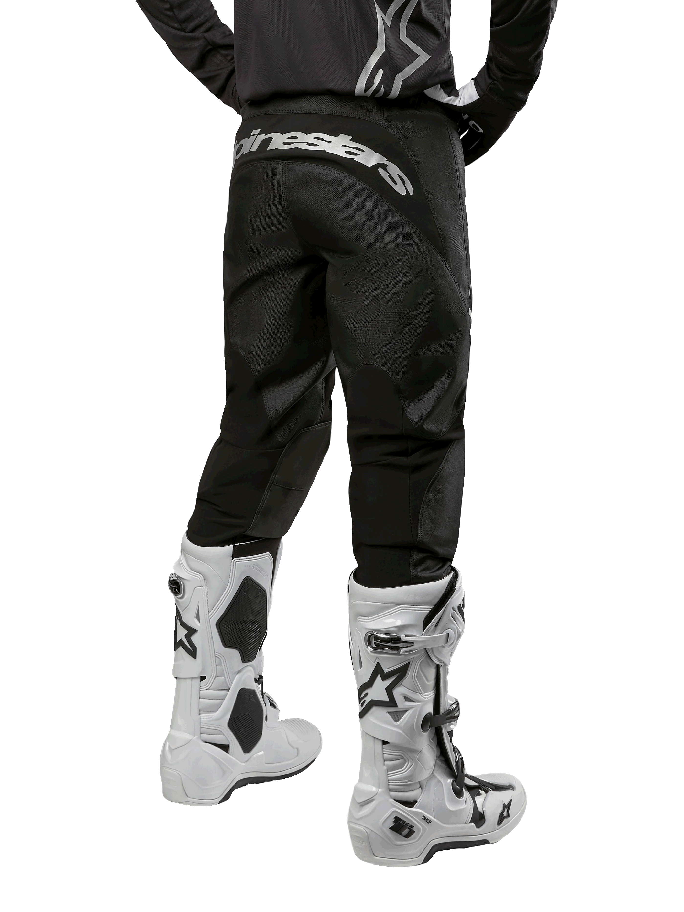 Zestaw Alpinestars 2024 Fluid Graphite, widok z tyłu czarno-szarych spodni motocrossowych z białym brandingiem Alpinestars na siedzeniu, biało-czarne buty motocrossowe, specjalistyczna odzież do wyścigów terenowych