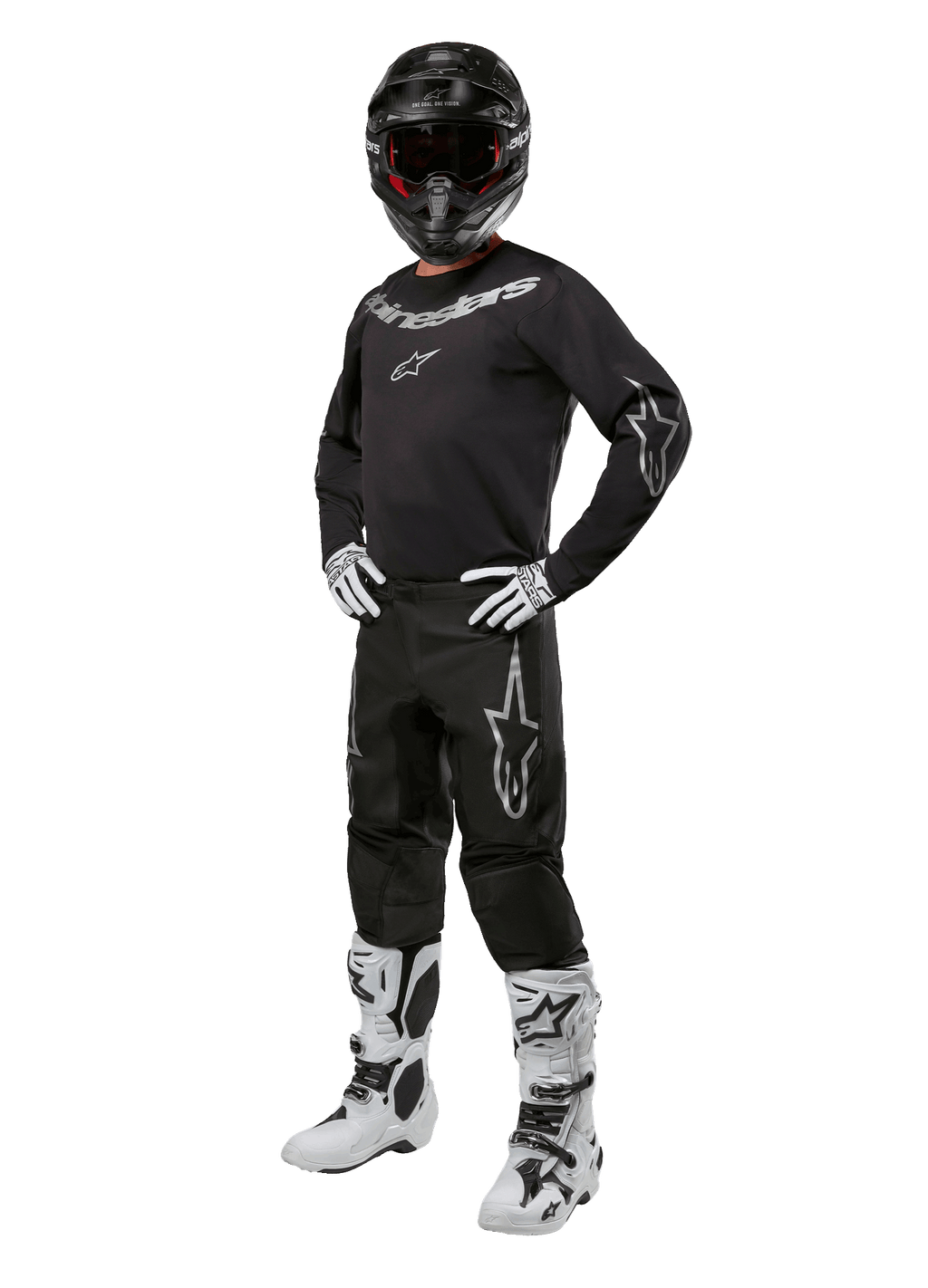 Alpinestars 2024 Fluid Graphite Gear Set, kompletny strój do wyścigów motocrossowych, czarny z szarymi i białymi logotypami, obejmujący koszulkę i spodnie noszone z dopasowanym czarnym kaskiem oraz biało-czarnymi rękawicami i butami, zaprojektowany z myślą o ochronie w terenie.