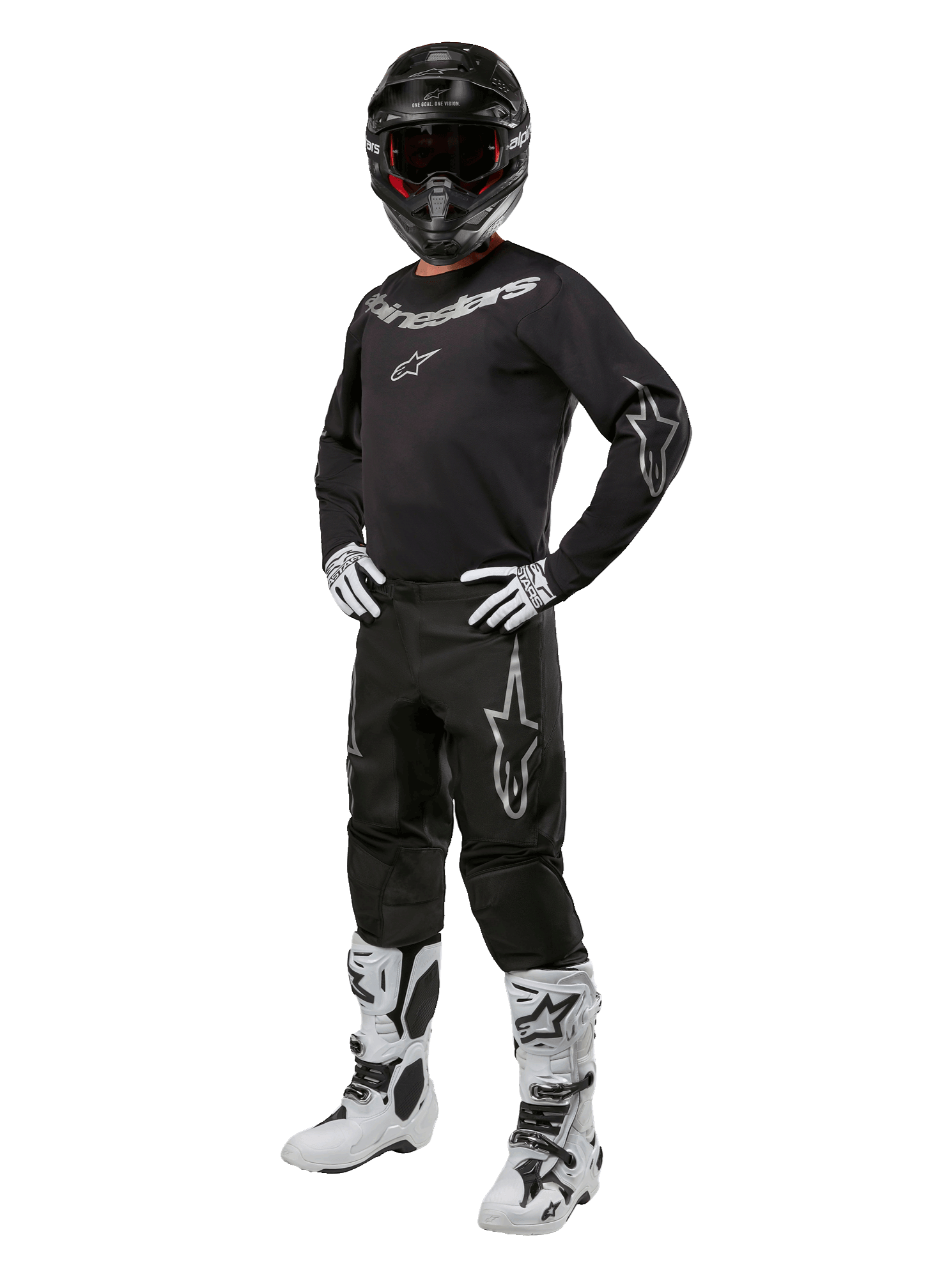Alpinestars 2024 Fluid Graphite Gear Set, kompletny strój do wyścigów motocrossowych, czarny z szarymi i białymi logotypami, obejmujący koszulkę i spodnie noszone z dopasowanym czarnym kaskiem oraz biało-czarnymi rękawicami i butami, zaprojektowany z myślą o ochronie w terenie.