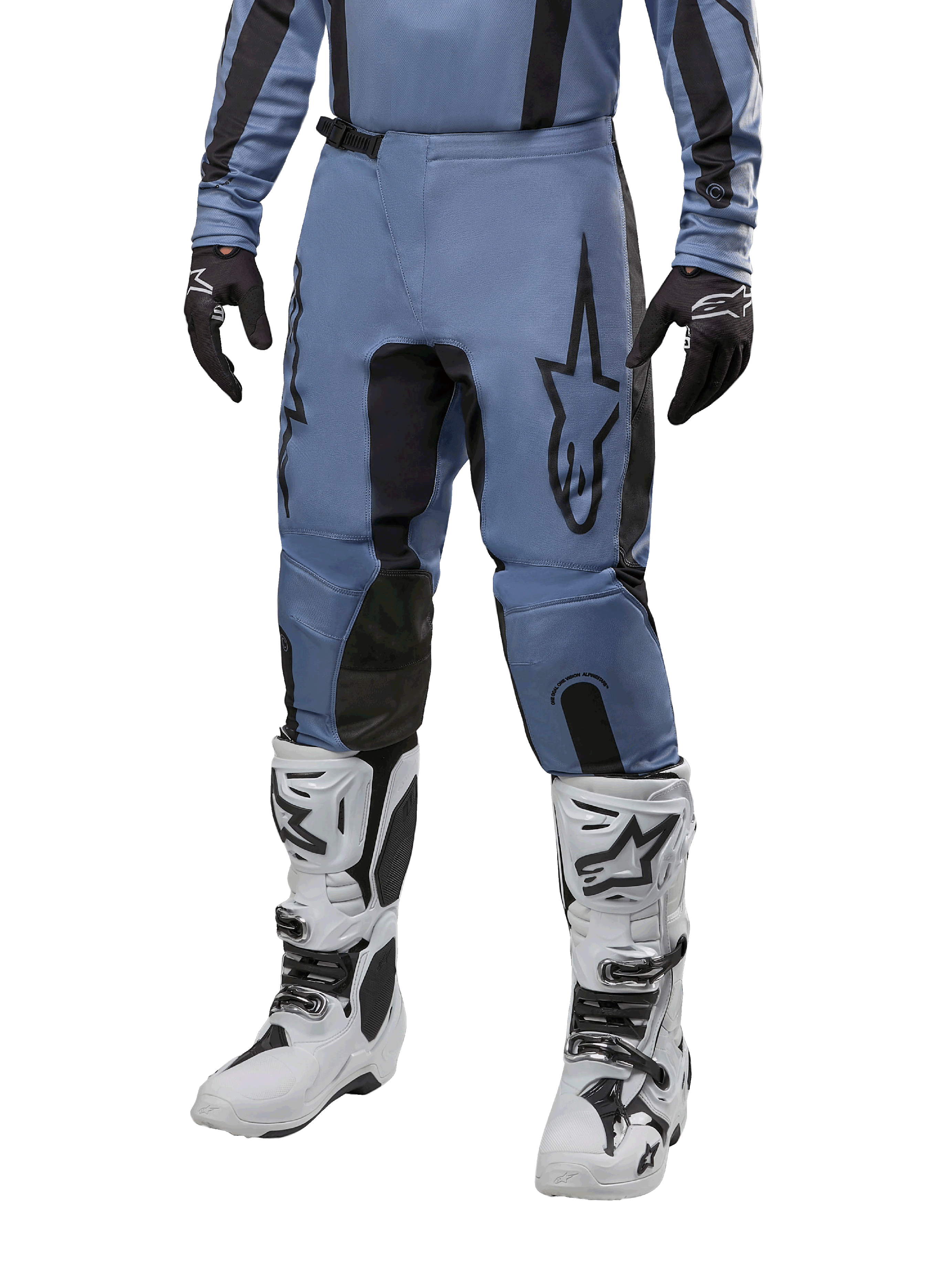 Spodnie Alpinestars Fluid Lurv 2024, spodnie motocrossowe, jasnoniebieskie i czarne, noszone z pasującą bluzą z długim rękawem i białymi butami motocrossowymi, z wyraźnym czarnym logo gwiazdy na udzie i wzmocnionymi panelami wewnętrznymi kolan, widok z przodu na białym tle