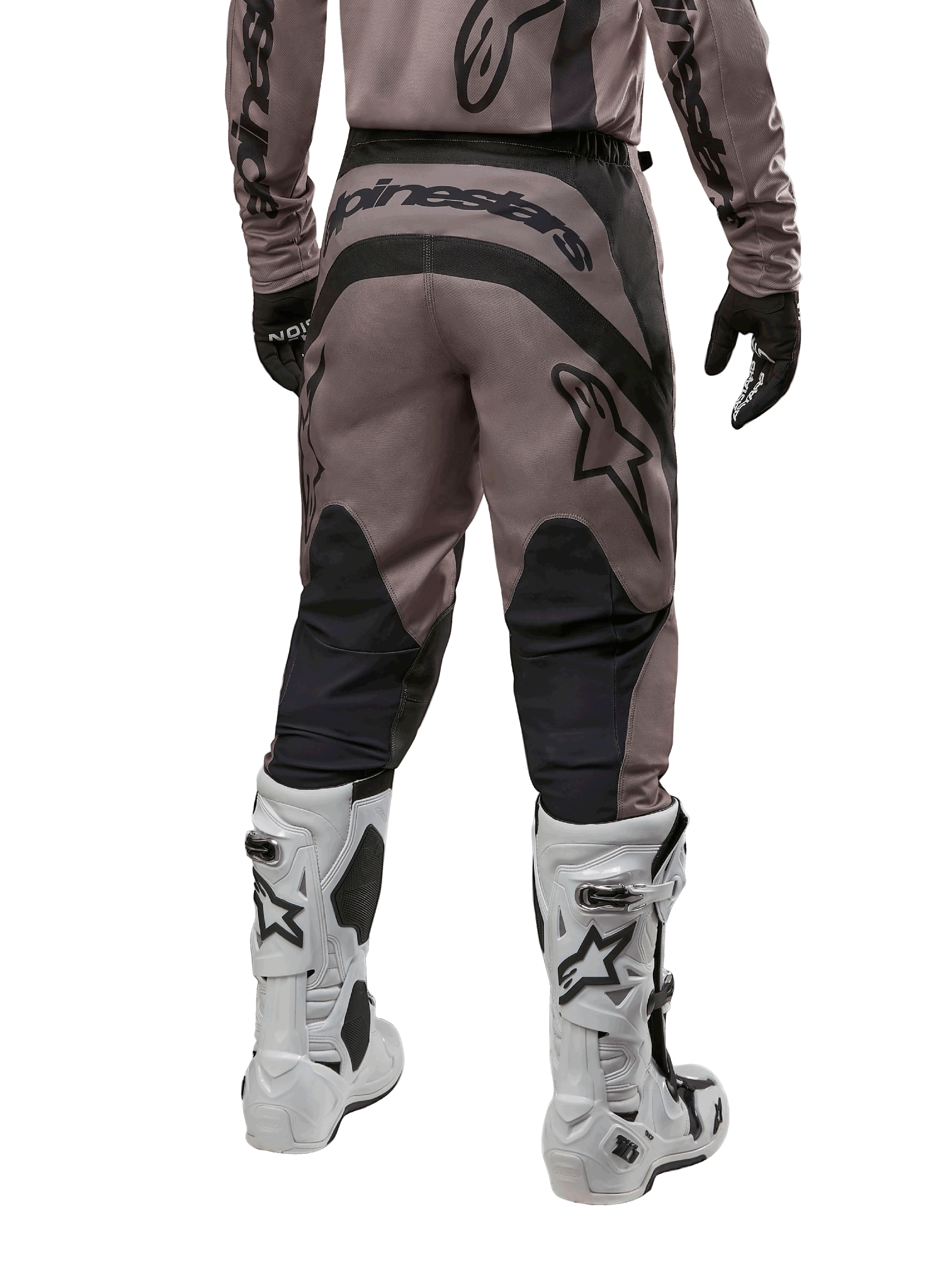 Alpinestars 2024 Fluid Lurv Pants, spodnie motocrossowe, kolor Mud Black, widok z tyłu ukazujący duże czarne logo Alpinestars na siedzeniu oraz czarne panele na łydkach, zestawione z biało-czarnymi butami motocrossowymi i pasującą koszulką
