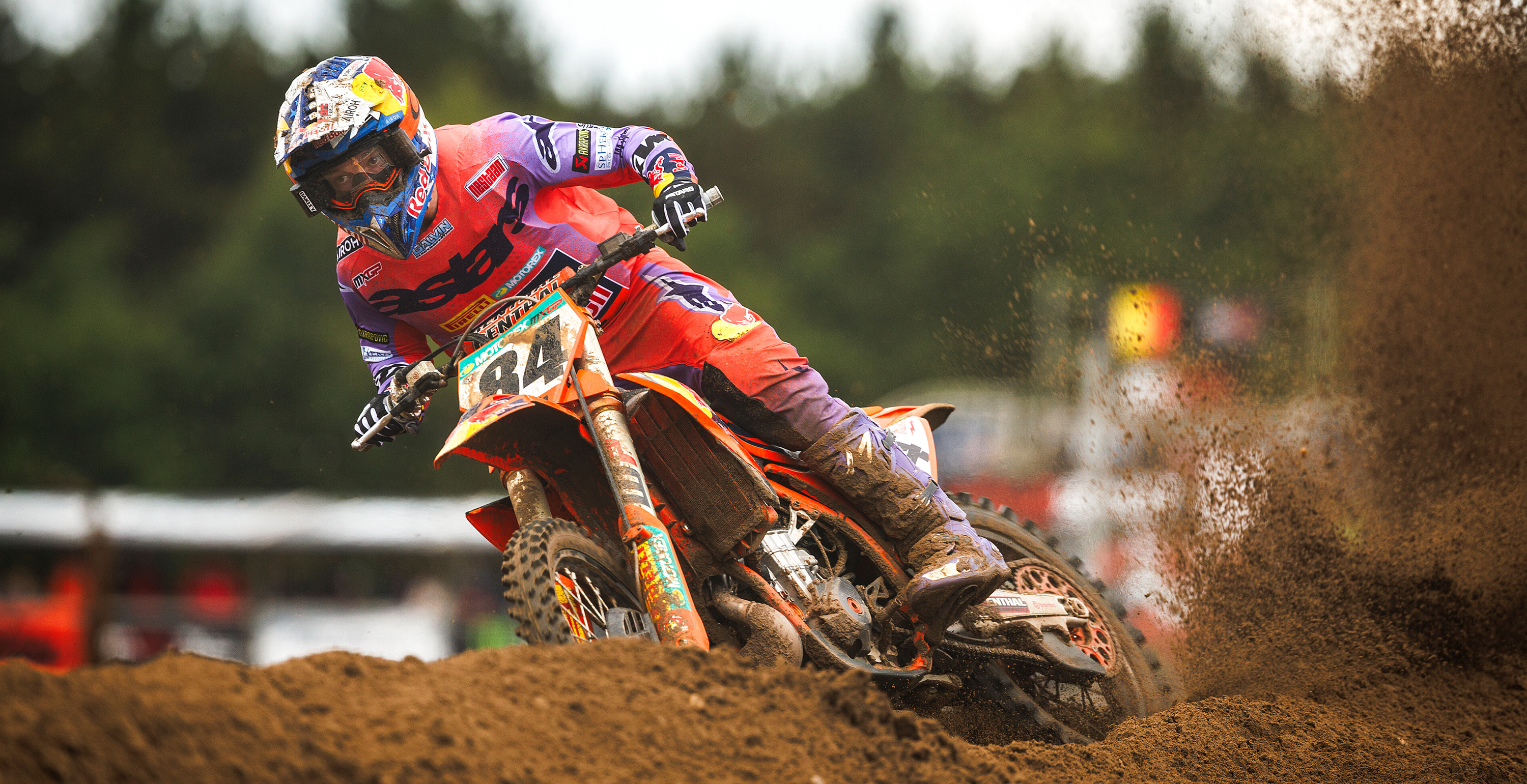 Jeffrey Herlings in action on a dirt track with a blurred background, wearing Alpinestars motocross jersey and Tech 10