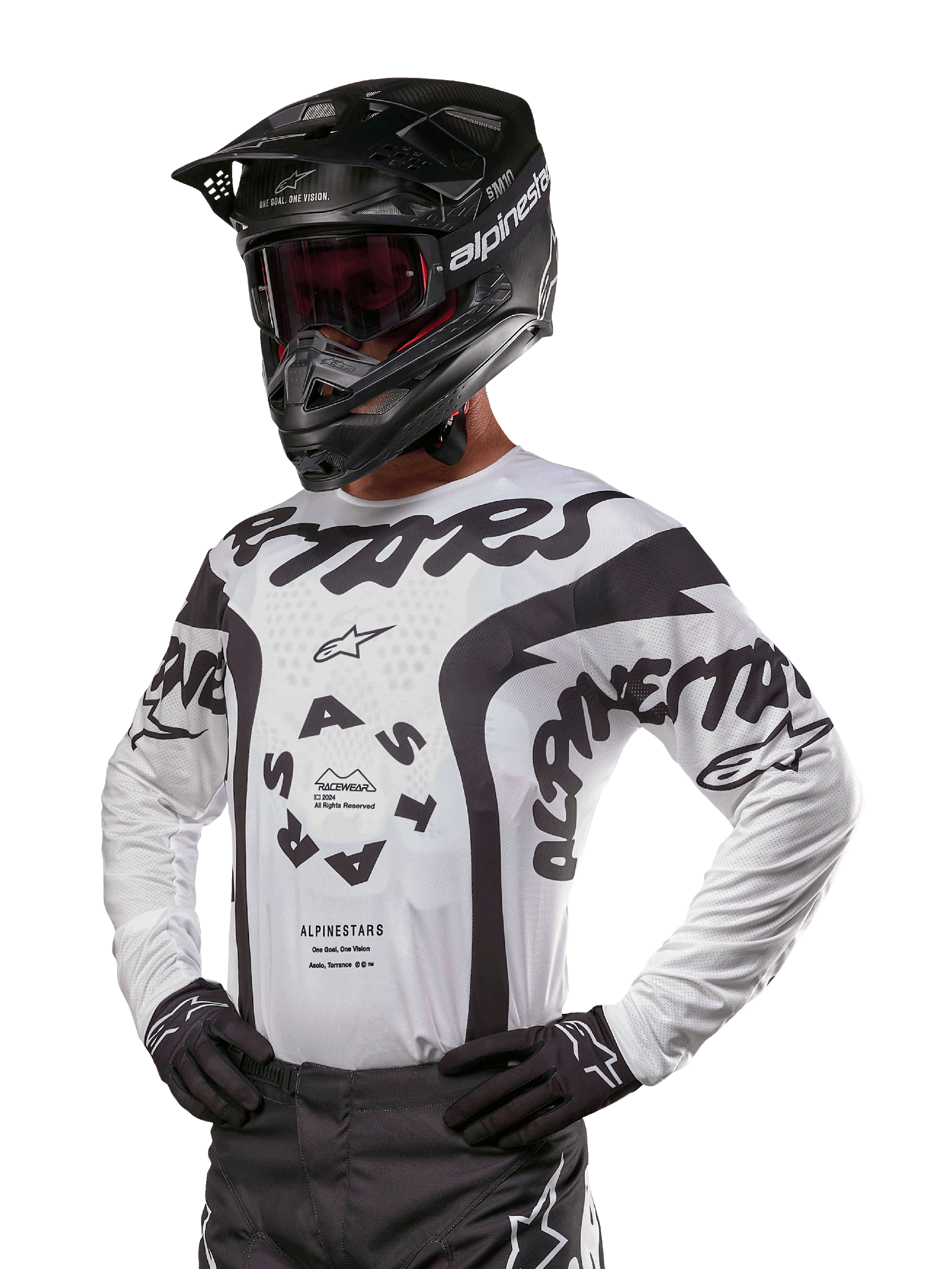 Alpinestars 2024 Racer Hana Jersey, biało-czarna koszulka motocrossowa, wyraziste grafiki z brandingiem Alpinestars i Astars, noszona z czarnym kaskiem i czarnymi rękawicami, wyczynowa odzież off-road MX