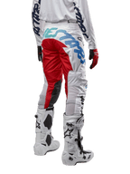 Alpinestars Racer Hana Pants 2024, spodnie motocrossowe, wielokolorowe białe z czerwonymi i niebieskimi akcentami, widok z tyłu pokazujący duże logo na siedzeniu, noszone z biało-czarnymi butami motocrossowymi, zaprojektowane dla wydajności i trwałości w terenie