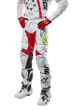 Alpinestars 2024 Racer Hana Pants, spodnie motocrossowe, białe z czerwonymi, niebieskimi i limonkowymi akcentami, ochronna konstrukcja ze skórzanymi panelami na kolanach, kompletny zestaw z pasującą bluzą, czerwonymi rękawicami i białymi butami z klamrami, sportowy design wyścigowy