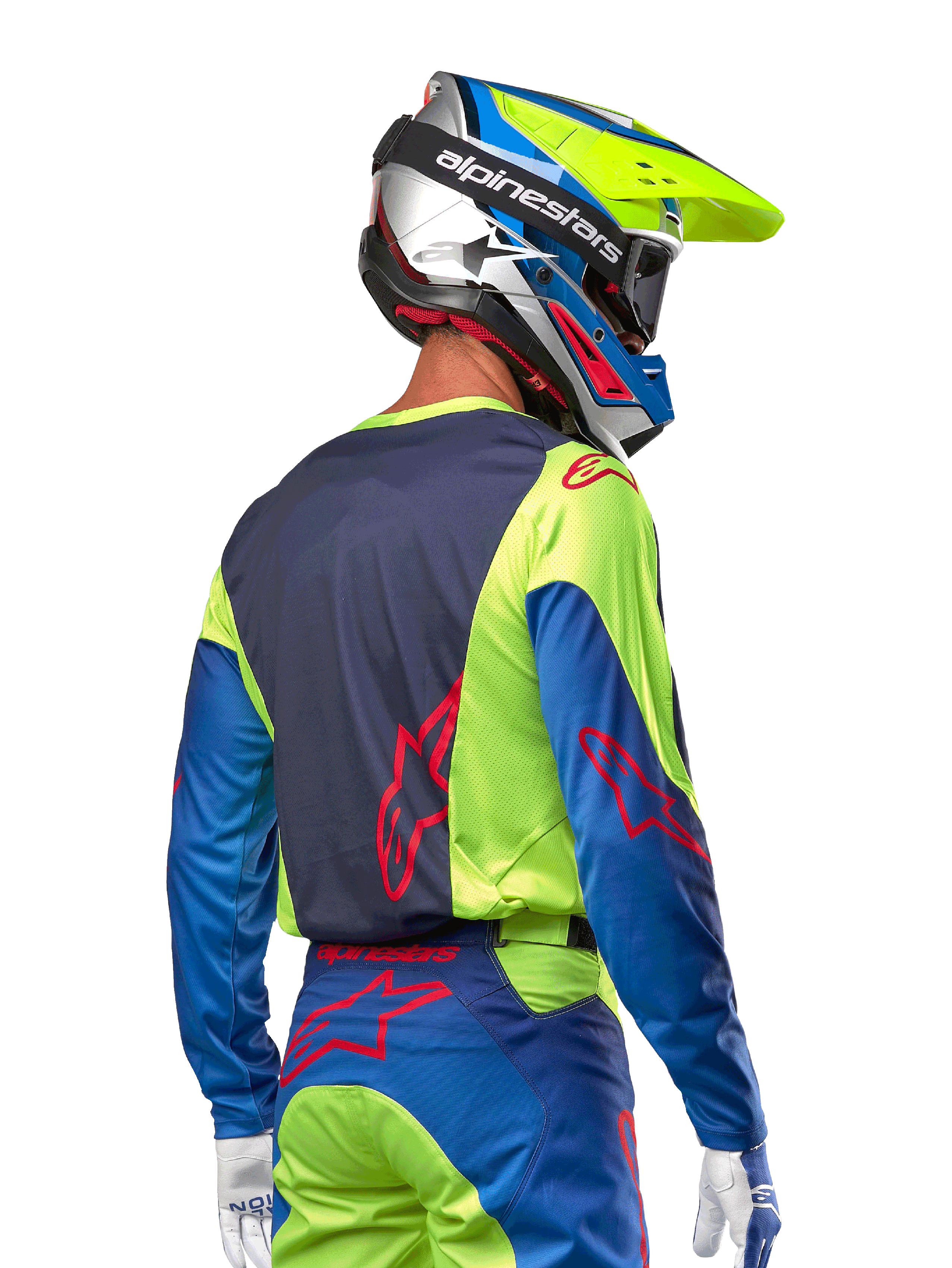 Motocyklista motocrossowy w koszulce Alpinestars 2024 Racer Hoen, kolor żółty fluo i granatowy (Blue Night Navy), z czerwonym logo gwiazdy na plecach, pasujące spodnie i kask wyścigowy, widok z tyłu prezentujący ergonomiczny design do jazdy terenowej.