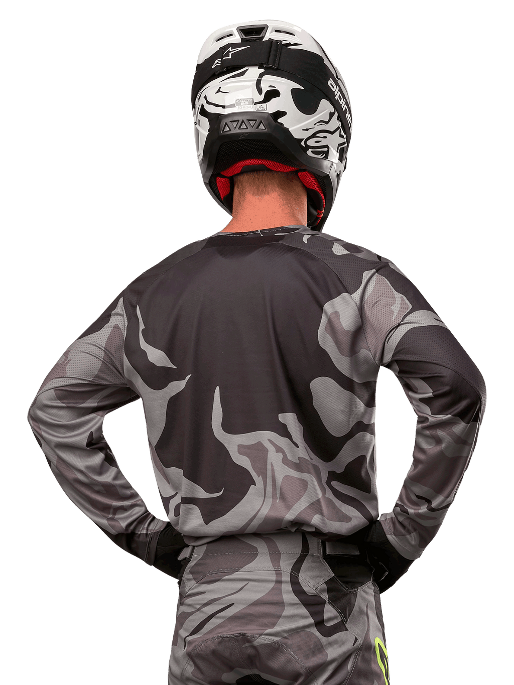 Alpinestars 2024 Racer Tactical Jersey, koszulka motocrossowa, Cast Gray Camo Magnet, widok z tyłu prezentujący szaro-czarny wzór kamuflażu, noszona z pasującymi spodniami i czarno-białym kaskiem, profesjonalna odzież do wyścigów terenowych