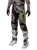 Alpinestars Racer Tactical Pants 2024, spodnie motocrossowe, szaro-czarne moro, limonkowe logo z gwiazdą, biało-czarne buty, czarne rękawice, odzież off-road