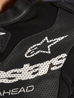 Zbliżenie na czarny, dwuczęściowy skórzany kombinezon Alpinestars Stella GP-R7 z perforowanymi panelami skórzanymi, dużym białym logo Alpinestars na klatce piersiowej i oddychającymi wstawkami z elastycznej tkaniny.