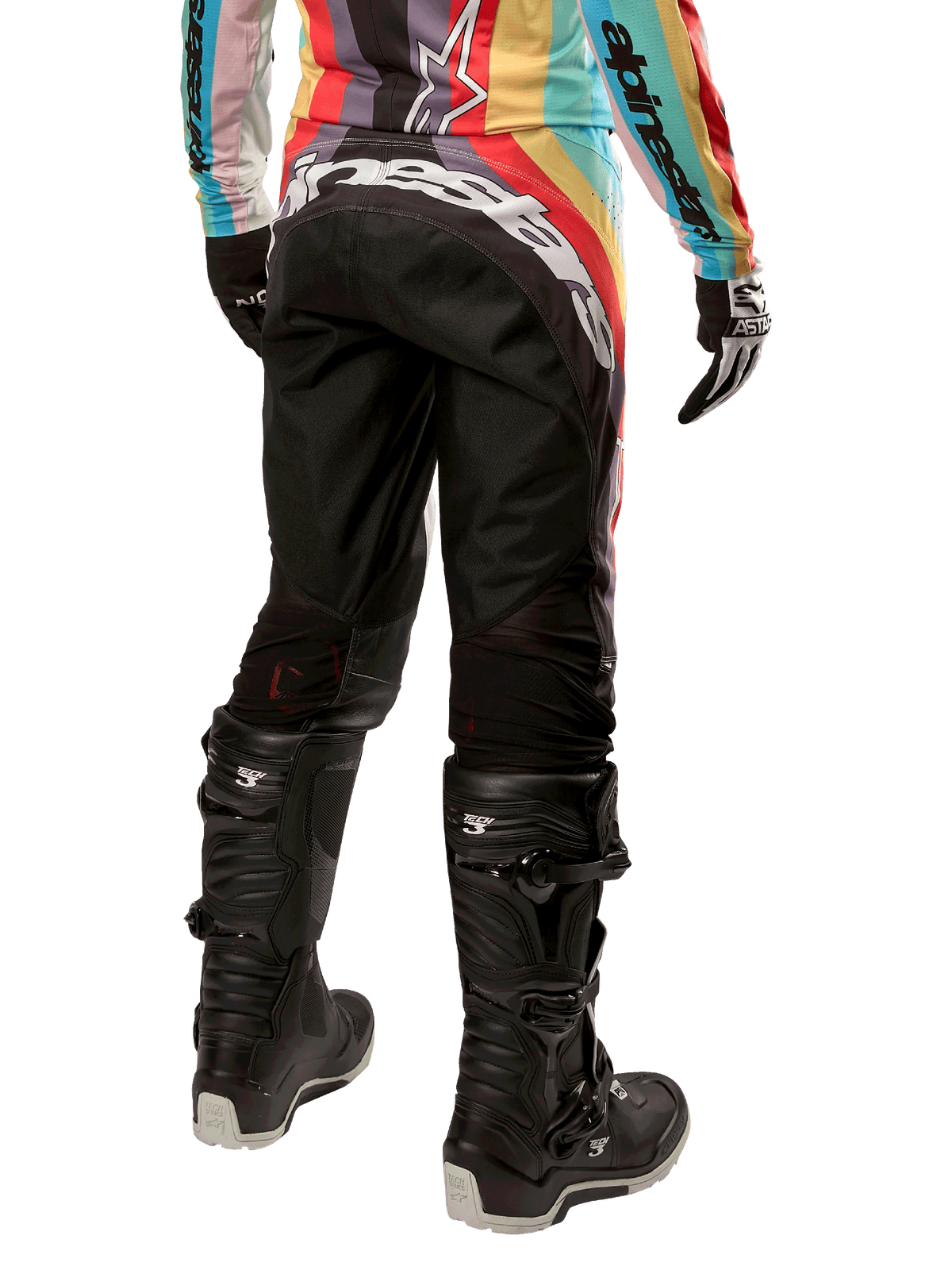 Alpinestars Stella Techstar Pants 2024 damskie, spodnie motocrossowe, czarne z wielokolorowymi elementami, widok z tyłu z wyraźnym białym logo na siedzeniu, czarne buty Tech 3 i pasująca wielokolorowa bluza, profesjonalna odzież terenowa