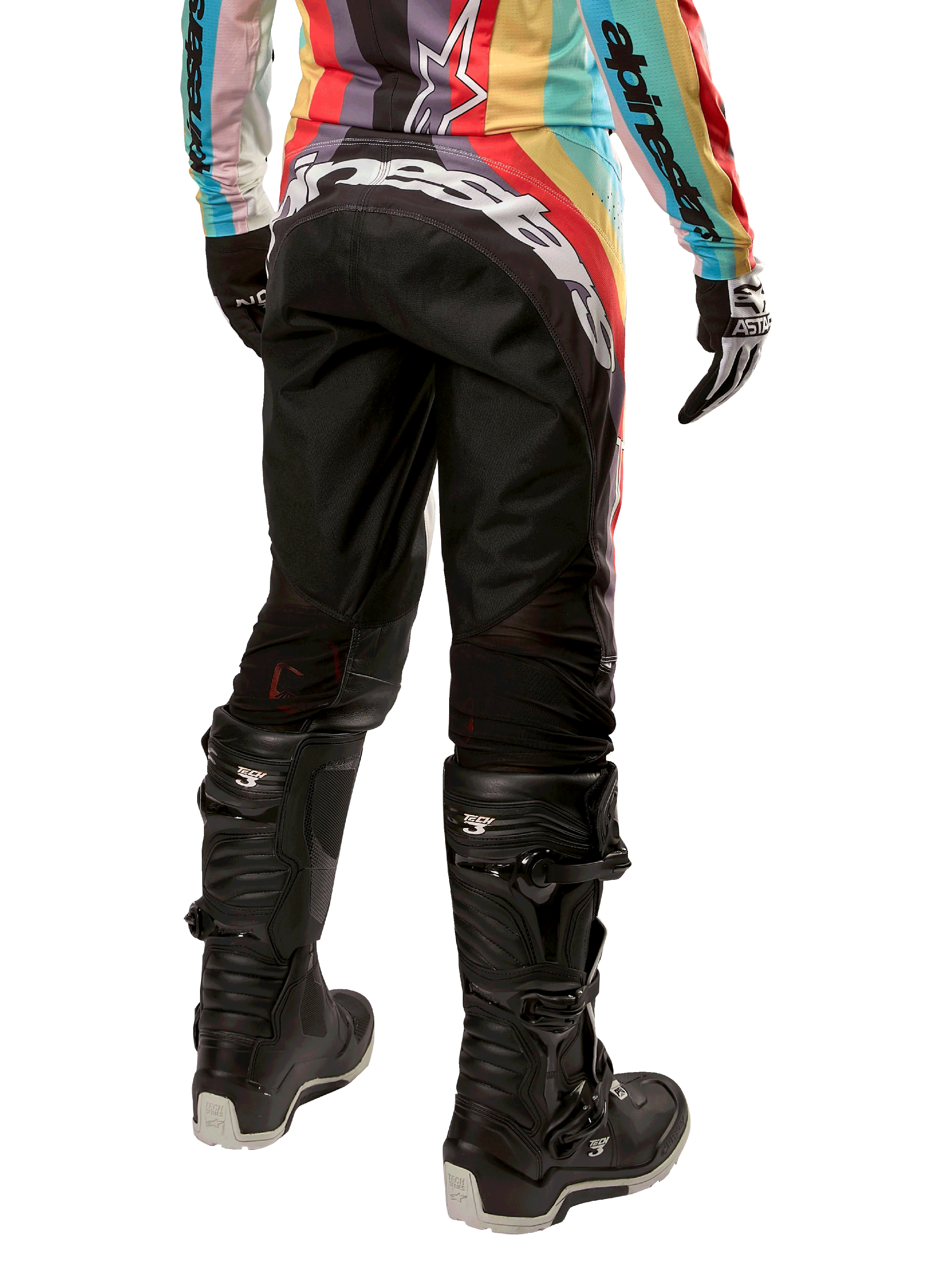 Alpinestars Stella Techstar Pants 2024 damskie, spodnie motocrossowe, czarne z wielokolorowymi elementami, widok z tyłu z wyraźnym białym logo na siedzeniu, czarne buty Tech 3 i pasująca wielokolorowa bluza, profesjonalna odzież terenowa