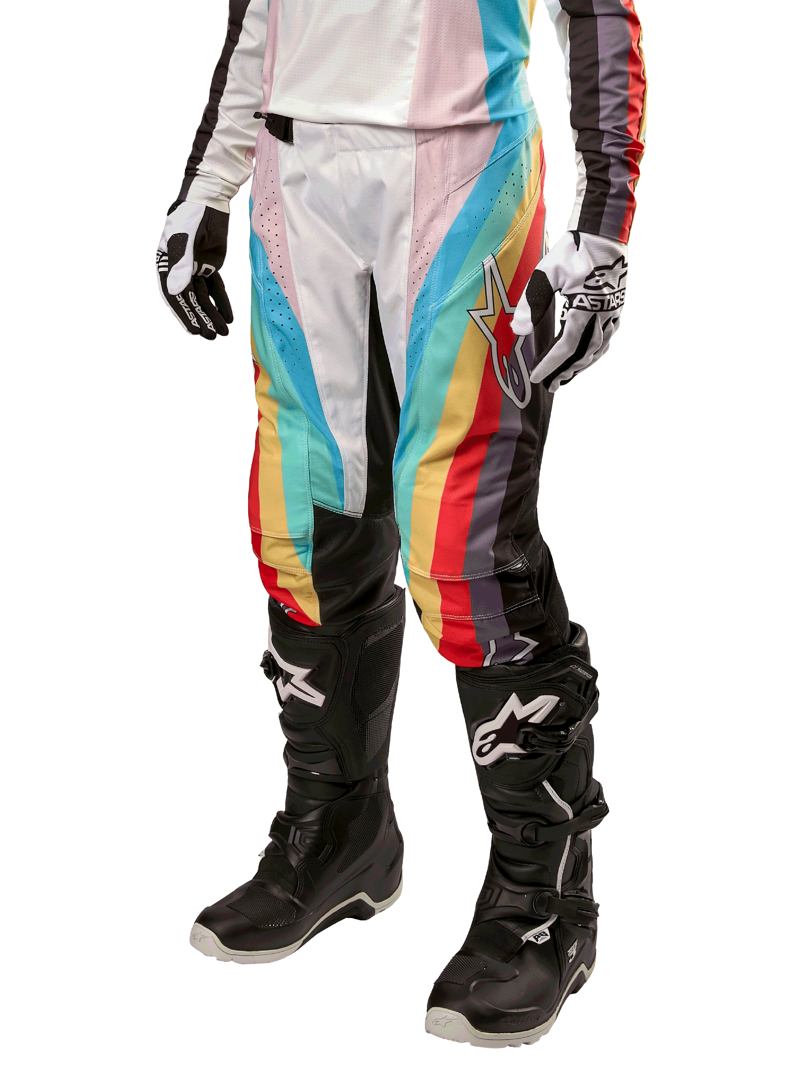 Alpinestars Stella Techstar 2024, damskie spodnie motocrossowe, czarne wielokolorowe z ukośnymi czerwonymi, żółtymi i niebieskimi pasami, widoczne z czarnymi butami i białymi rękawicami, z czarnymi panelami ochronnymi na kolanach i wyrazistym logo do wyścigów off-road