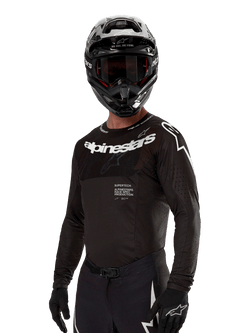 Alpinestars 2024 Supertech Ward Jersey, Motocross Jersey, Black and White, long-sleeve performance gear with bold Alpinestars branding, worn with matching helmet and gloves, athletic fit for off-road riding