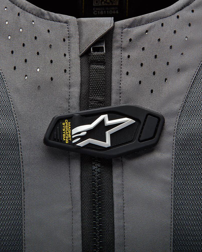 Poduszka powietrzna Alpinestars Tech-Air 5, magnetyczna klapka z logo na szarej perforowanej tkaninie.