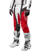 Spodnie Alpinestars 2024 Techstar Ocuri, spodnie motocrossowe, kolor czerwony Mars Red, biały i czarny, zestawione z dopasowaną biało-czarną koszulką, czarnymi rękawicami oraz białymi butami wyścigowymi z klamrami, techniczna odzież ochronna na białym tle.