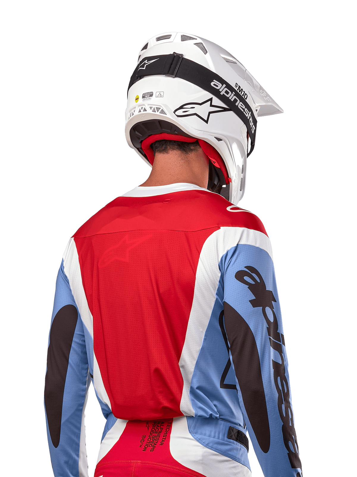 Alpinestars 2024 Techstar Ocuri Jersey, koszulka motocrossowa, jasnoniebieska, czerwona Mars Red i biała, widok z tyłu na motocyklistę w pasującym białym kasku i czarnych goglach, wyraźne czarne logo na rękawach, ergonomiczny krój wyścigowy dla wydajności off-road