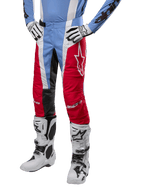 Spodnie Alpinestars Techstar Ocuri 2024, spodnie motocrossowe, jasnoniebieskie, czerwone i białe, noszone z jasnoniebieską bluzą i białymi butami, z logo gwiazdy na udzie i wzmocnionymi kolanami, kompletny strój do wyścigów off-road