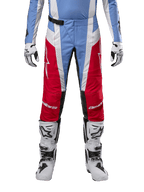 Spodnie Alpinestars Techstar Ocuri 2024, spodnie motocrossowe, jasnoniebieskie, czerwone i białe, widok z przodu od pasa w dół, w zestawieniu z biało-czarnymi butami i rękawicami motocrossowymi, techniczna odzież do wyczynowej jazdy terenowej