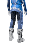 Alpinestars Techstar Pneuma Pants 2024, spodnie motocrossowe, ciemnogranatowe i jasnoniebieskie, widok z tyłu z wyraźnym białym logo na siedzeniu i wzmocnionymi czarnymi panelami, zestawione z białymi butami motocrossowymi Tech 10