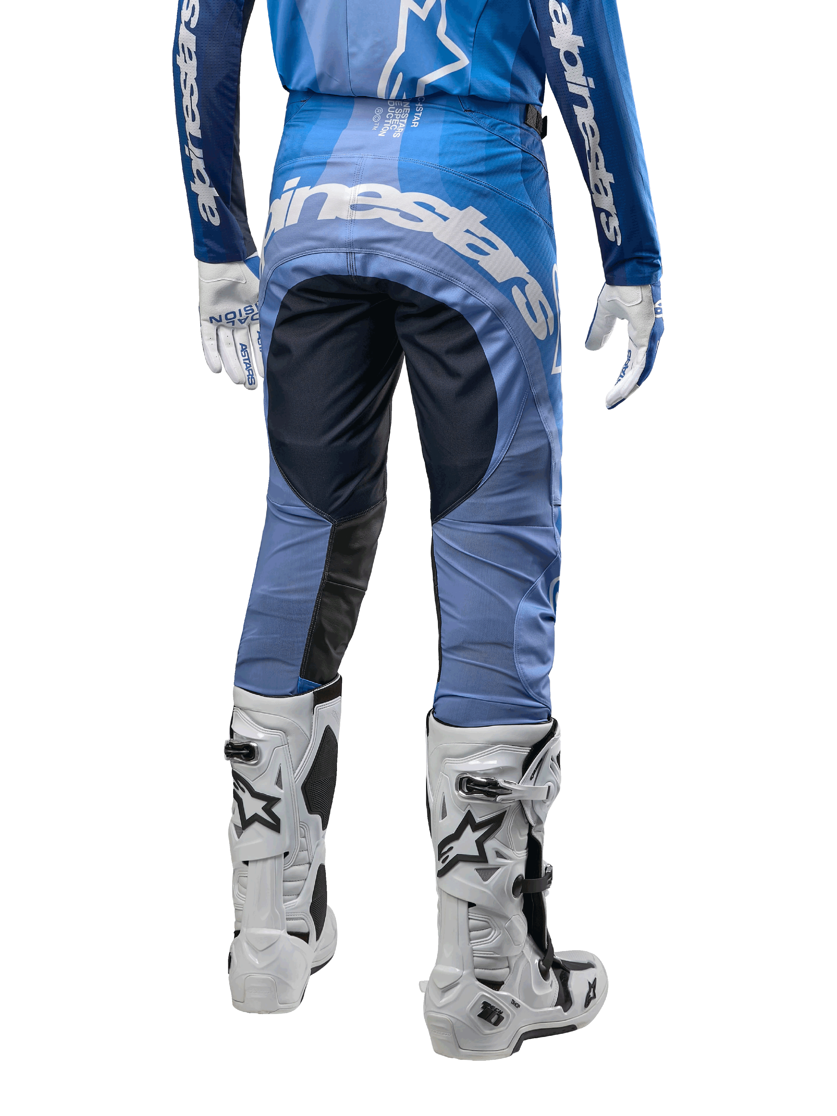 Alpinestars Techstar Pneuma Pants 2024, spodnie motocrossowe, ciemnogranatowe i jasnoniebieskie, widok z tyłu z wyraźnym białym logo na siedzeniu i wzmocnionymi czarnymi panelami, zestawione z białymi butami motocrossowymi Tech 10
