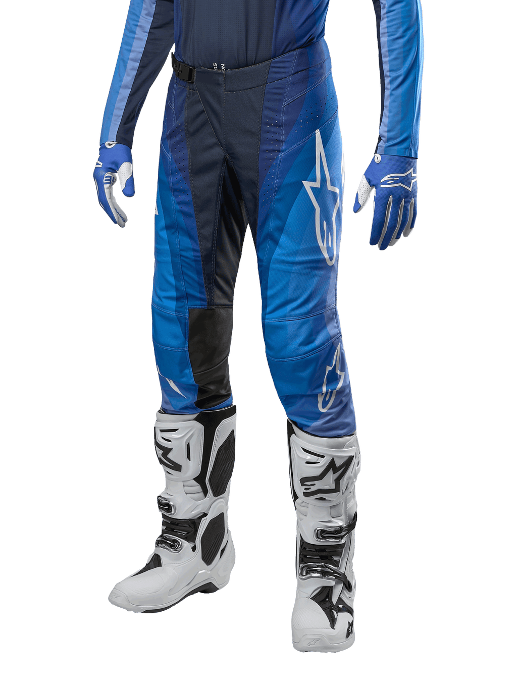Alpinestars Techstar Pneuma Pants 2024, spodnie motocrossowe, ciemnogranatowy i jasnoniebieski, noszone z pasującą niebieską bluzą i białymi butami, białe logo na udzie, teksturowane strefy przyczepności, smukły sportowy design do wyścigów terenowych