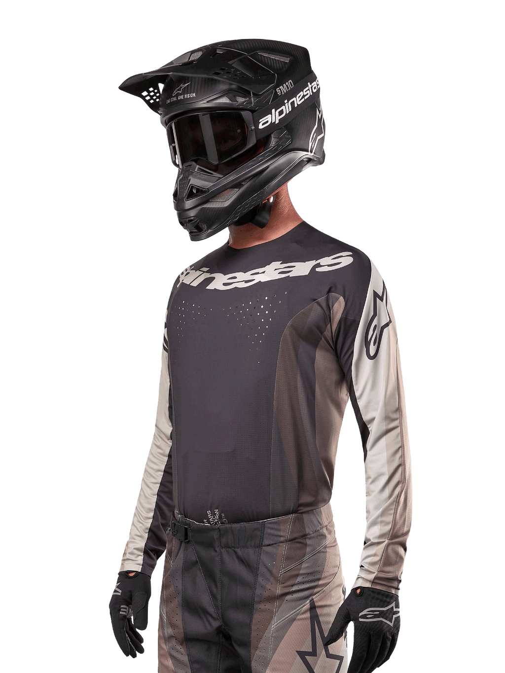 Alpinestars Techstar Pneuma Jersey 2024, koszulka motocrossowa, ciemnopiaskowa i szara (Iron Dust Gray), techniczna koszulka z długim rękawem, laserowo wycinane perforacje i białe logo, noszona z pasującymi spodniami i czarnym kaskiem, sportowy krój off-road