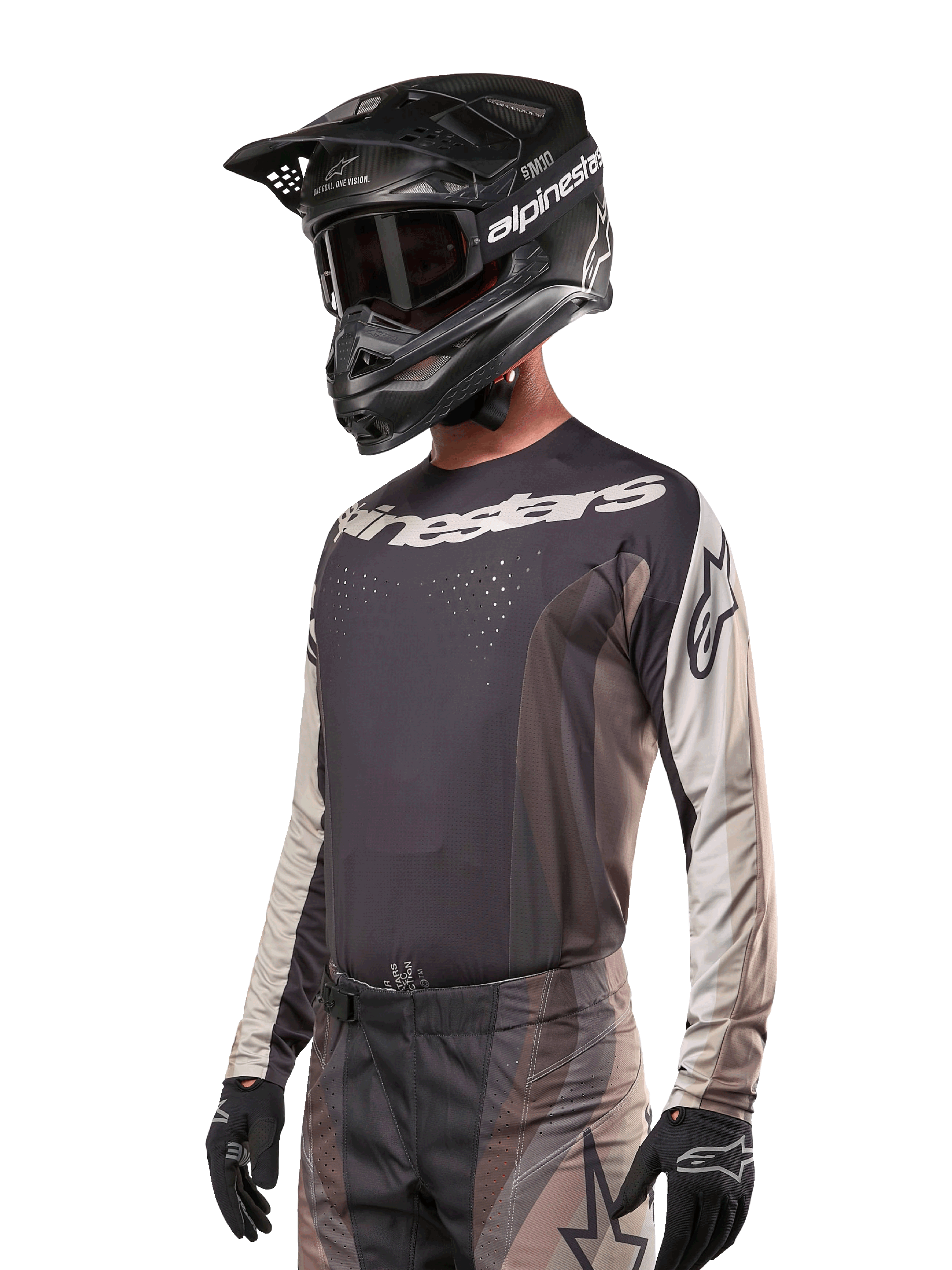 Alpinestars Techstar Pneuma Jersey 2024, koszulka motocrossowa, ciemnopiaskowa i szara (Iron Dust Gray), techniczna koszulka z długim rękawem, laserowo wycinane perforacje i białe logo, noszona z pasującymi spodniami i czarnym kaskiem, sportowy krój off-road