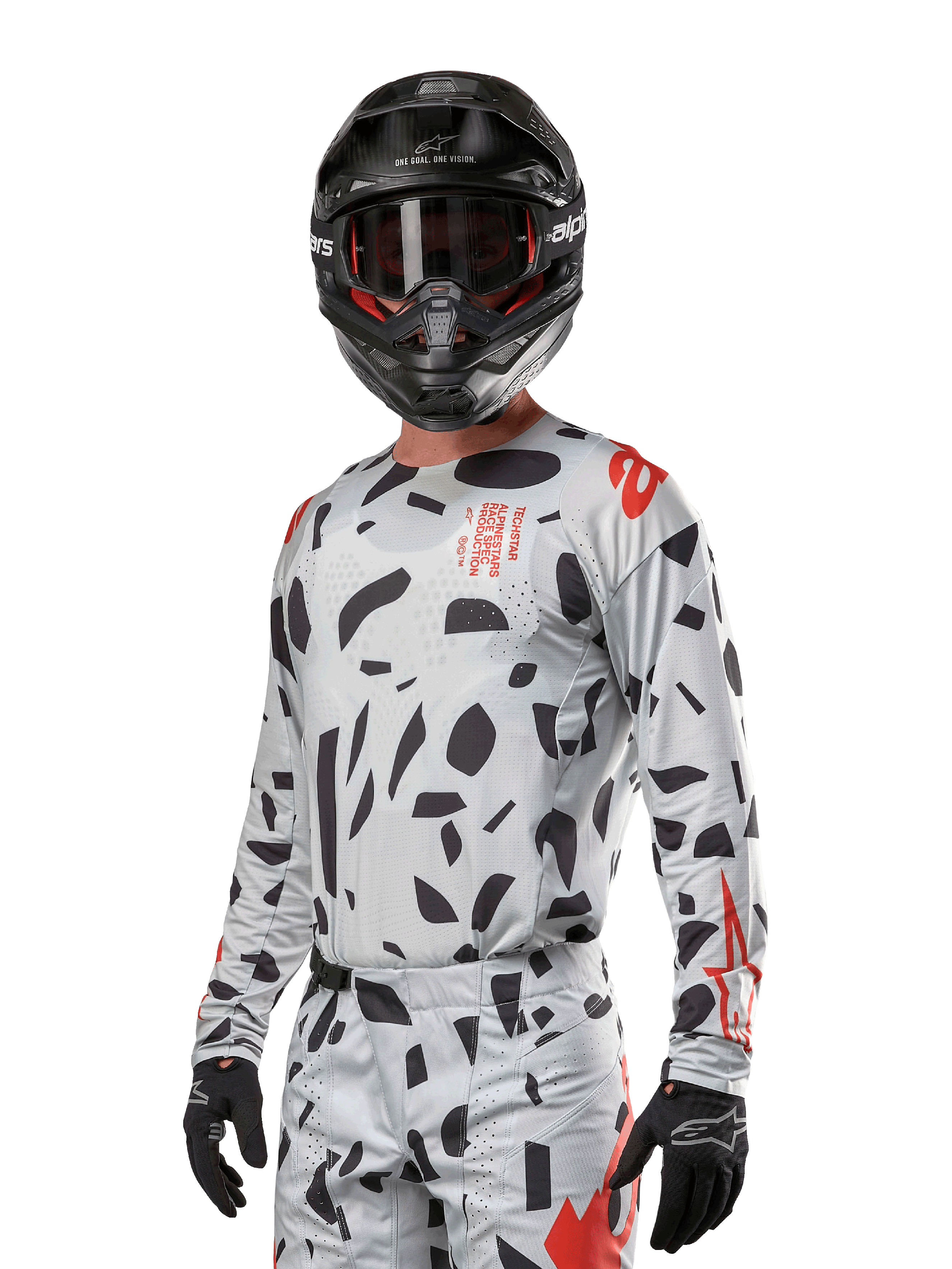 Alpinestars 2024 Techstar Rantera Jersey, koszulka motocrossowa, kolor Haze Gray Camo z czarnymi abstrakcyjnymi wzorami i czerwonymi akcentami, model z długim rękawem noszony z pasującym czarnym kaskiem i rękawicami, techniczna odzież do wyścigów terenowych