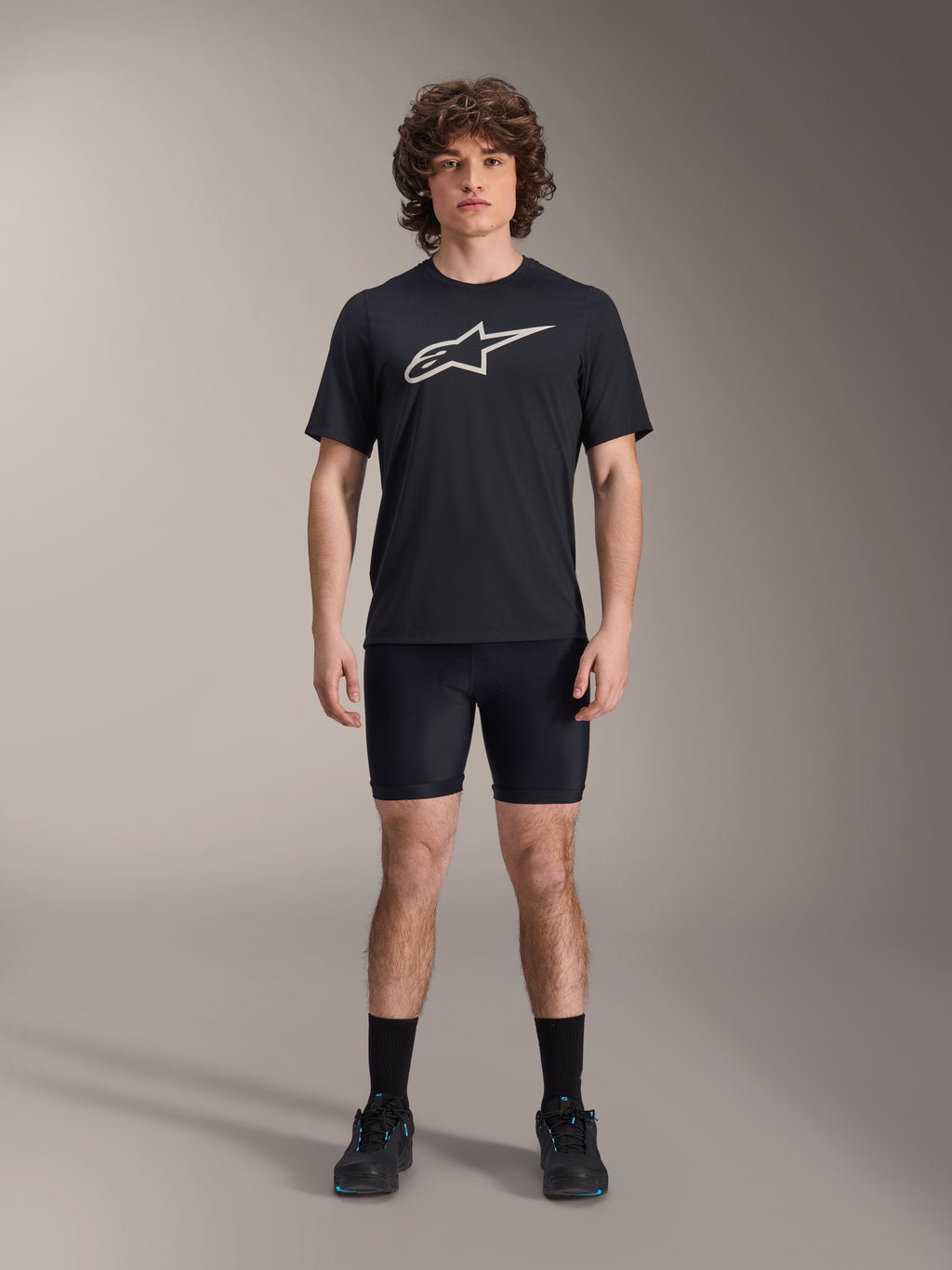 Alpinestars A-Dura Liner Shorts, czarne rowerowe spodenki wewnętrzne, model w czarnej koszulce z logo Alpinestars i czarnych butach rowerowych, dopasowany krój dla wydajności MTB i komfortu w siodle