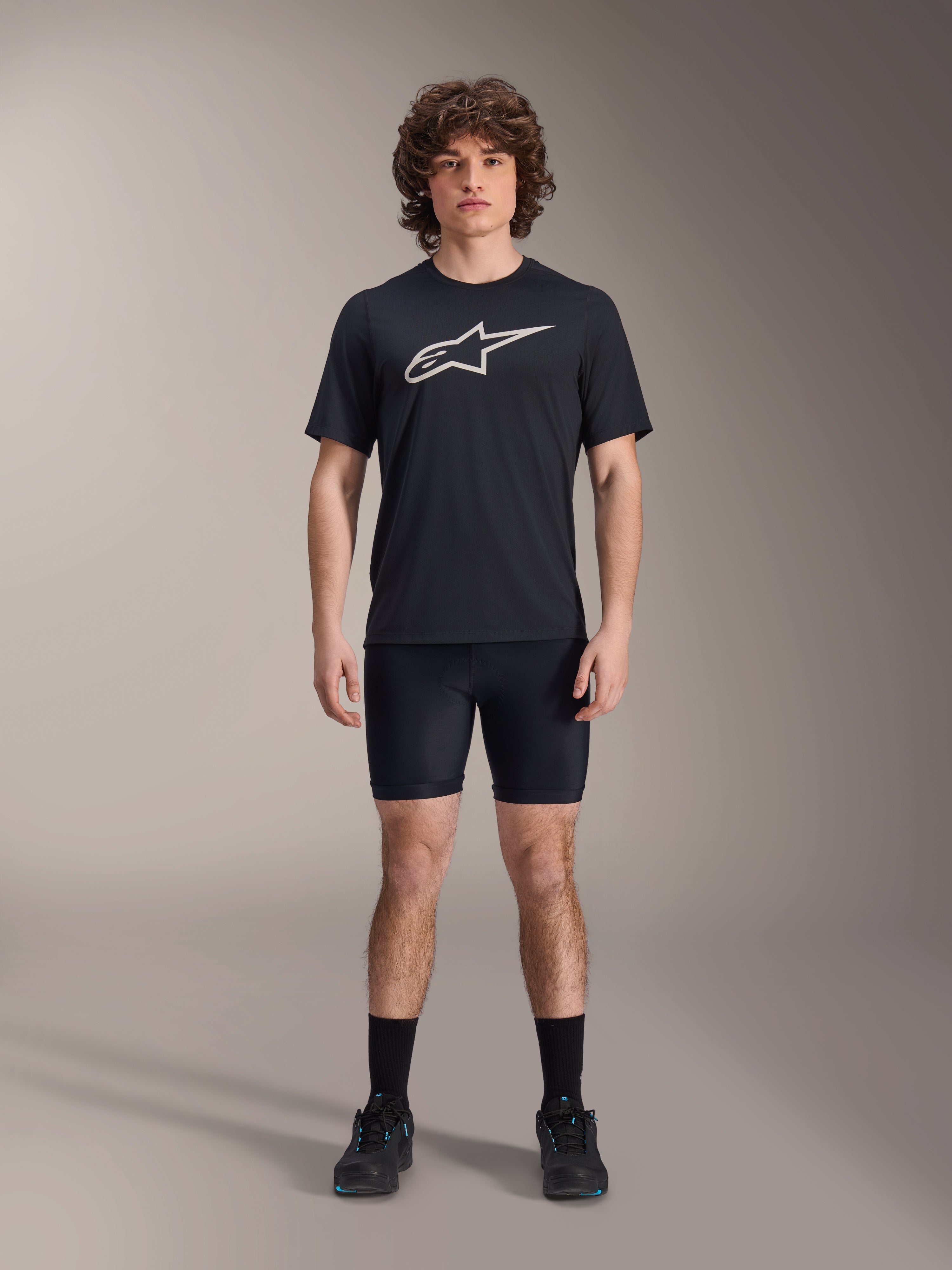 Alpinestars A-Dura Liner Shorts, czarne rowerowe spodenki wewnętrzne, model w czarnej koszulce z logo Alpinestars i czarnych butach rowerowych, dopasowany krój dla wydajności MTB i komfortu w siodle