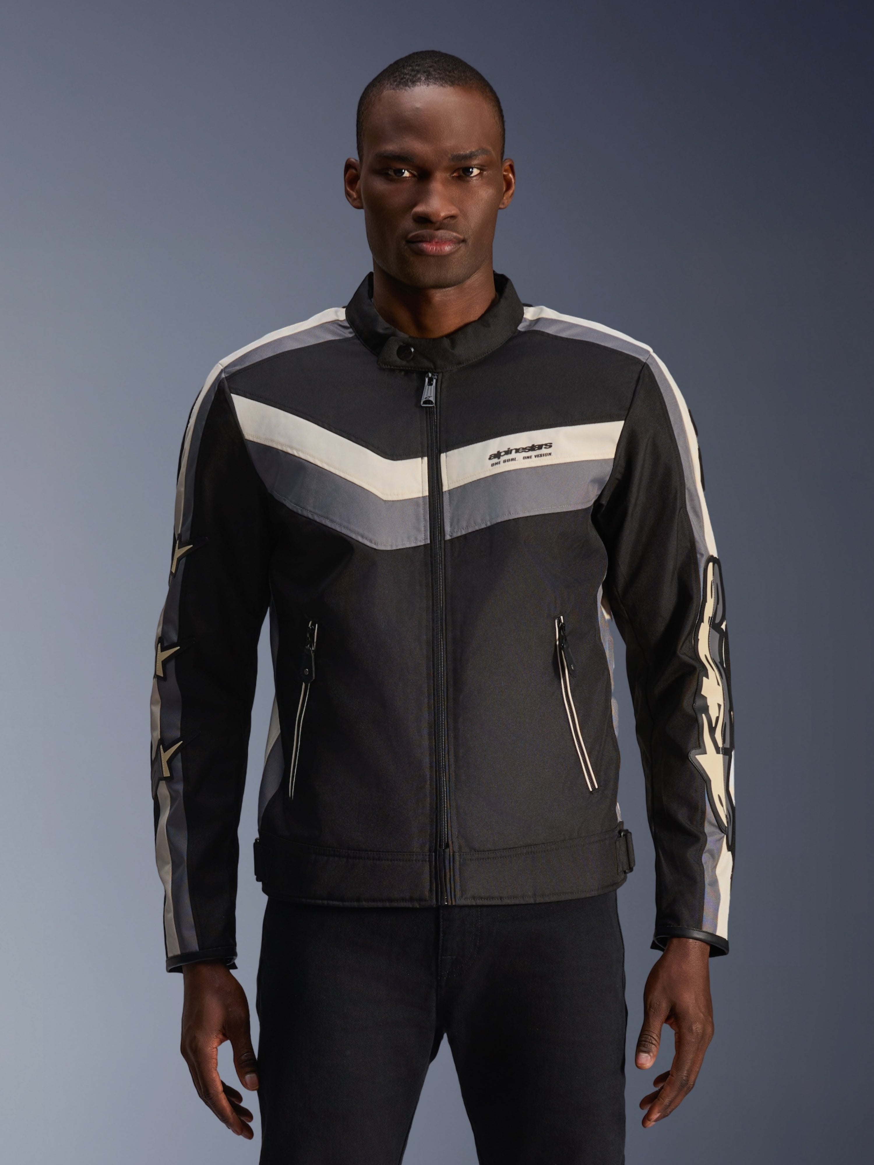 Alpinestars T-Dyno WR Jacket, tekstylna kurtka motocyklowa, czarna, ciemnoszara i ecru, wzory w paski typu chevron na klatce piersiowej i rękawach, krój inspirowany stylem vintage ze stójką, nowoczesna miejska odzież drogowa