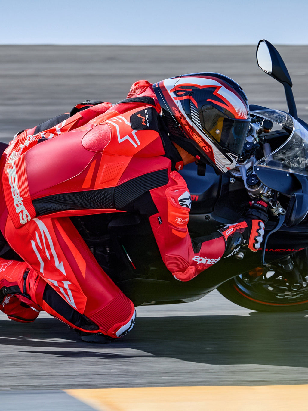 Alpinestars GP Plus V4 Sprint 1PC, skórzany kombinezon wyścigowy, czerwony i biały, Tech-Air® Ready, motocyklista na torze.