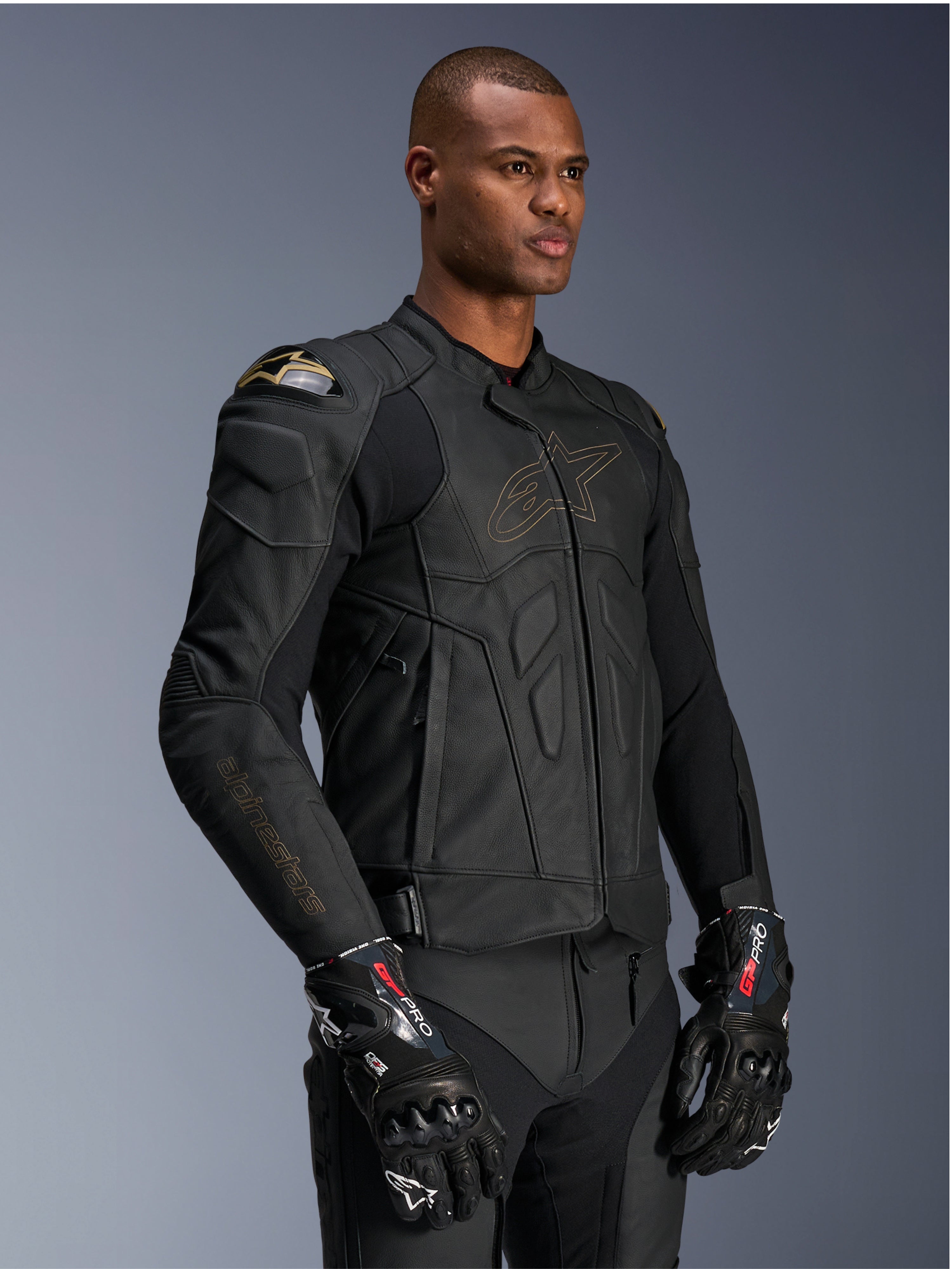 Alpinestars Dusk Leather Jacket, skórzana kurtka motocyklowa Black Laser, wykonana z wysokiej jakości skóry ze złotym konturem logo Alpinestars i brandingiem na rękawach, zewnętrzna ochrona ramion DFS, w zestawieniu z rękawicami GP Pro, profesjonalna odzież wyścigowa