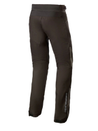 Alpinestars AST-1 V2 Waterproof Pants Long, czarne tekstylne spodnie motocyklowe, widok z tyłu ukazujący odblaskowe detale i pionowe logo na dolnej części nogawki, trwała odzież motocyklowa na każdą pogodę