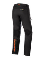 Spodnie Alpinestars AMT-10R Drystar® XF, czarne z pomarańczowymi akcentami, widok z tyłu ukazujący pionowe pomarańczowe logo Alpinestars na lewej nogawce, teksturowane panele na kolanach oraz branding Kevlar i Matryx, techniczne motocyklowe spodnie adventure touring