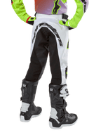 Alpinestars Youth 2024 Racer Lucent Pants, spodnie motocrossowe, biało-czarne z neonowymi akcentami, widok z tyłu ukazujący duży elastyczny panel oraz logo Alpinestars, noszone z czarno-białymi butami Alpinestars Tech Series