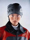 Alpinestars RSRV Onyx Beanie, czapka beanie w ciemnoszarym kolorze z białym logo, owalnie wycięcia z oczkami, osoba w czerwono-czarnej kurtce z wysokim kołnierzem