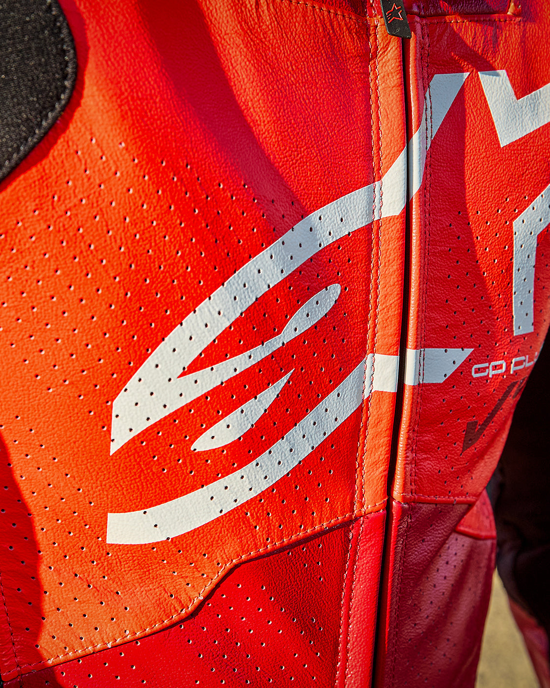 Alpinestars GP Plus V4 Sprint 1PC Leather Suit, red and white perforated leather motorcycle suit with close-up chest logo.